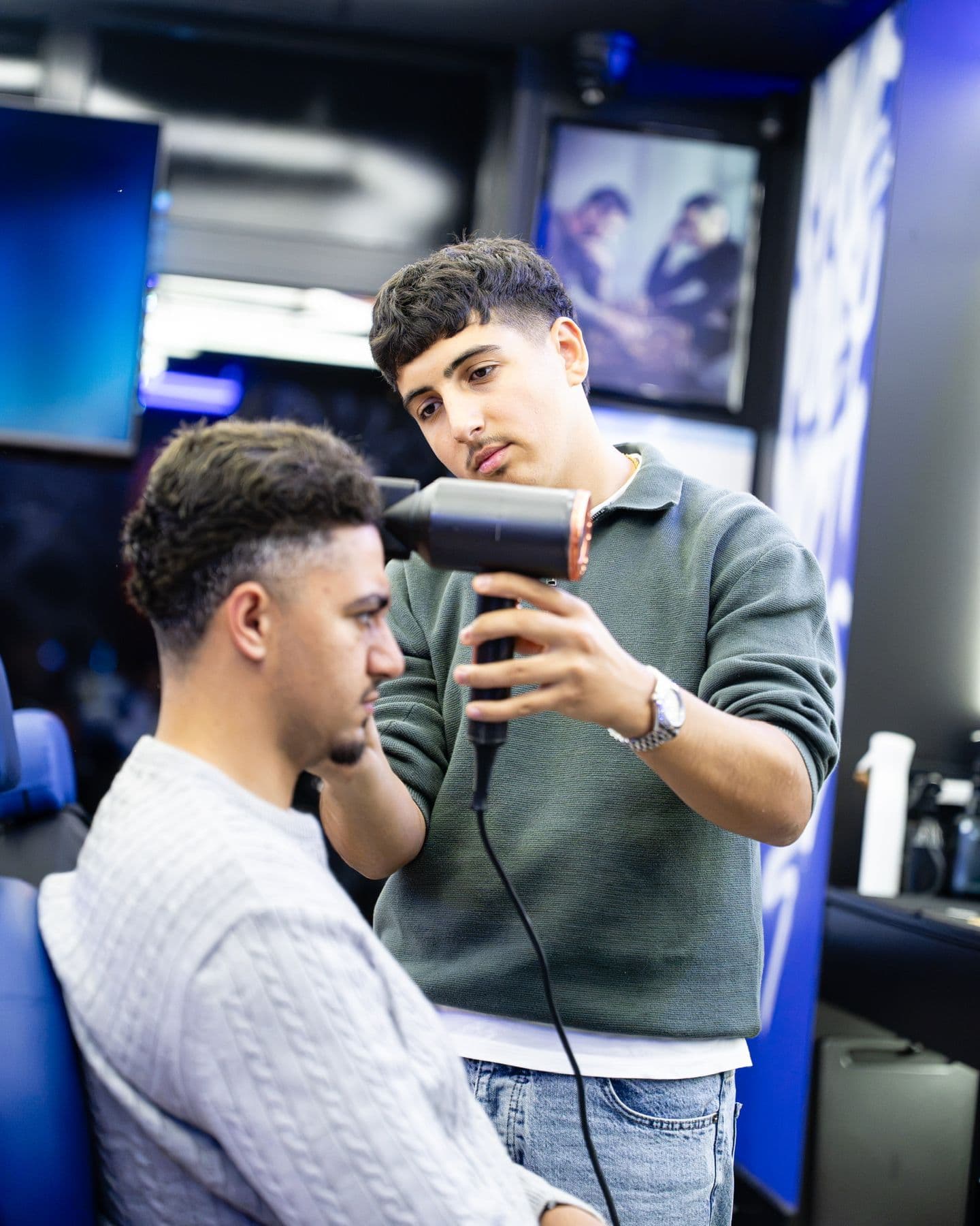 Barber föhnt het haar van een klant