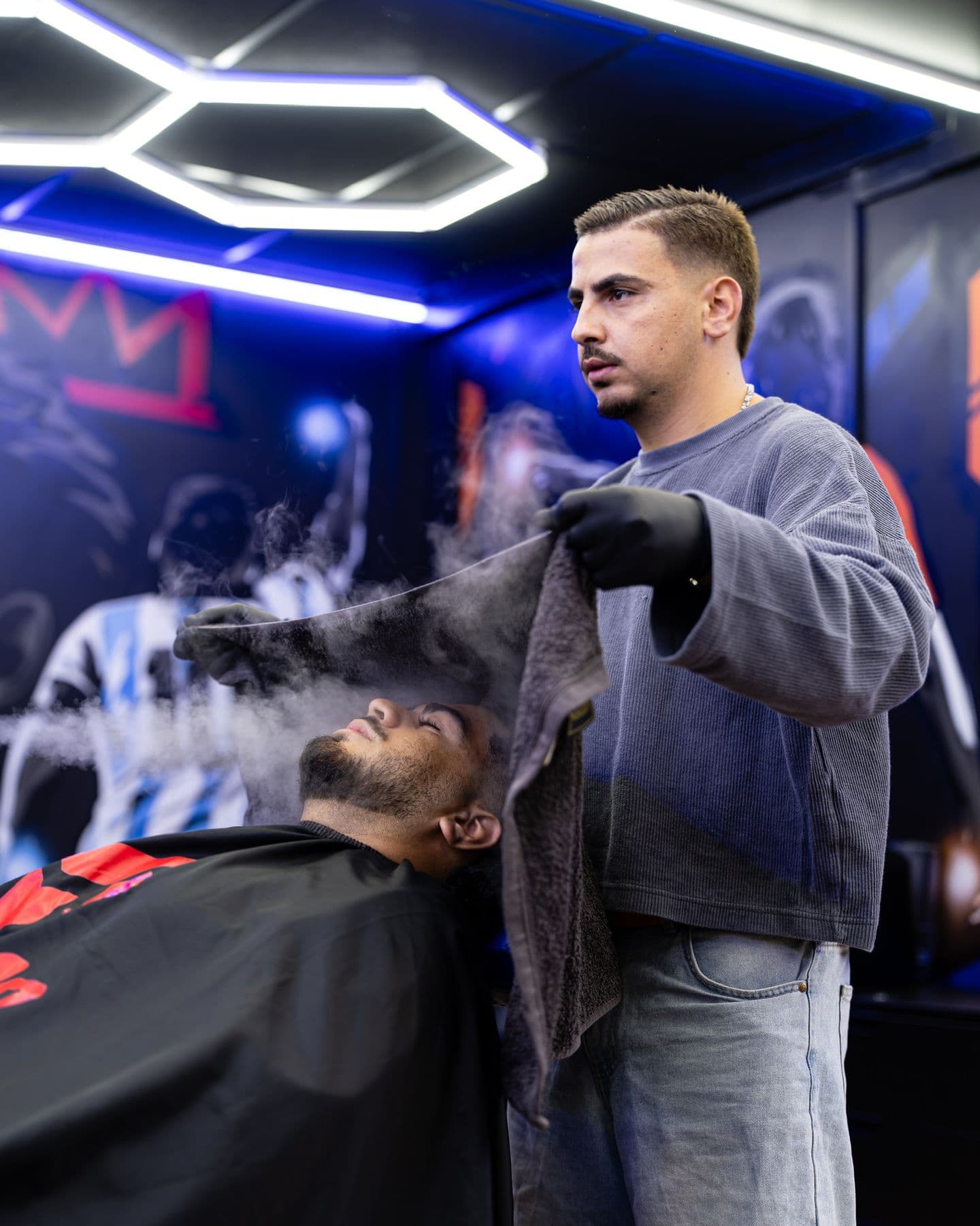 Barber houdt een dampende hot towel boven een klant